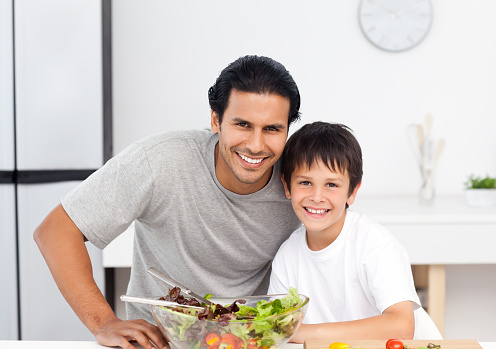 Cute boy with his father in the kitchen for lunch