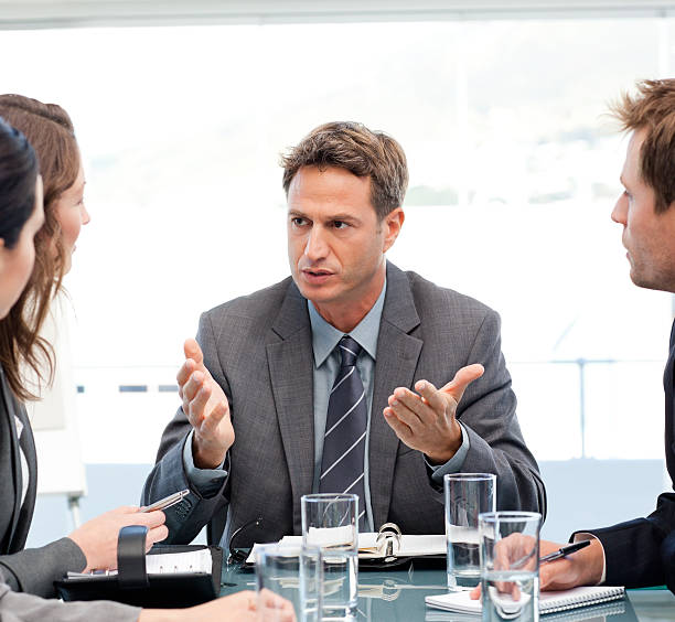 istock Severe manager talking to his team at a table 153714347