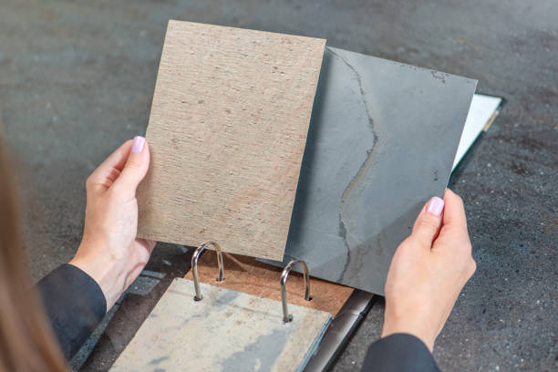 istock Samples of decorative stone. A woman designer holds in her hands several samples of natural stone for wall decoration and furniture production. 1537143796