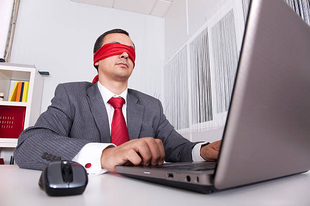 istock Blindfolded businessman working on laptop 153714926