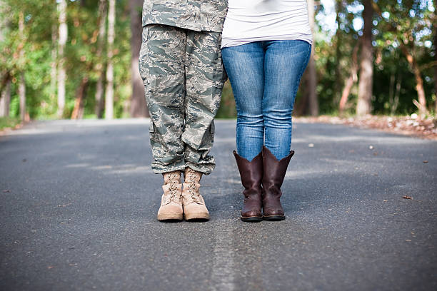 Soldier and wife standing on street separated by white line stock photo