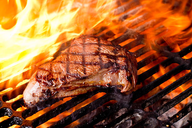 Meat grilling over hot coals for a barbecue with friends