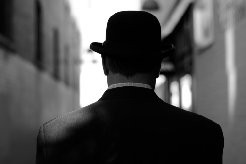 Unidentified man in wearing a bowler hat, similar in style to a more photorealistic Magritte.  Image in black-and-white.