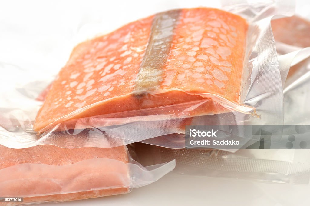 A picture of some pink, bagged salmon frozen salmon fillet in vacuum packages close up Frozen Stock Photo