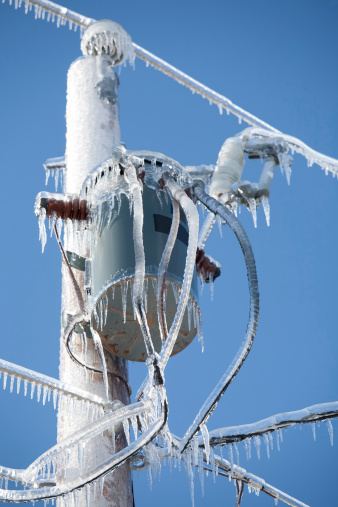 Ice incrusted power lines and transformer on a   winter day.