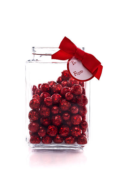 Jar with red glittery candy, and gift tag stock photo