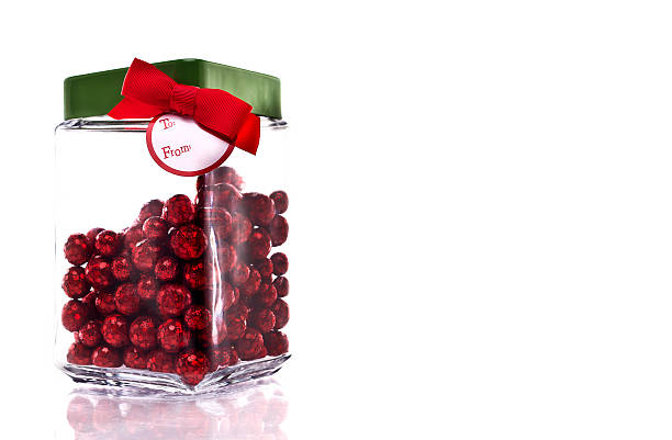 Jar with red glittery candy, green lid and gift tag stock photo