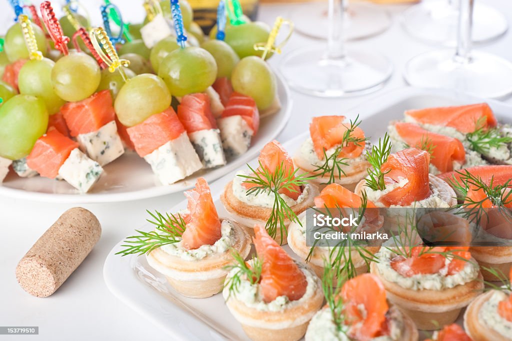 Snacks with salty salmon and cheese for wine Snacks with salty salmon, cheese and grapes for wine Appetizer Stock Photo