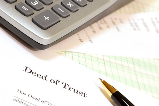 Close-up of corner of calculator, Deed of Trust document and pen.