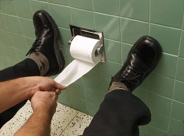 Hands pulling toilet paper.