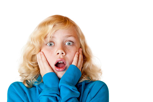 Young beautiful blond girl looks shocked into camera stock photo