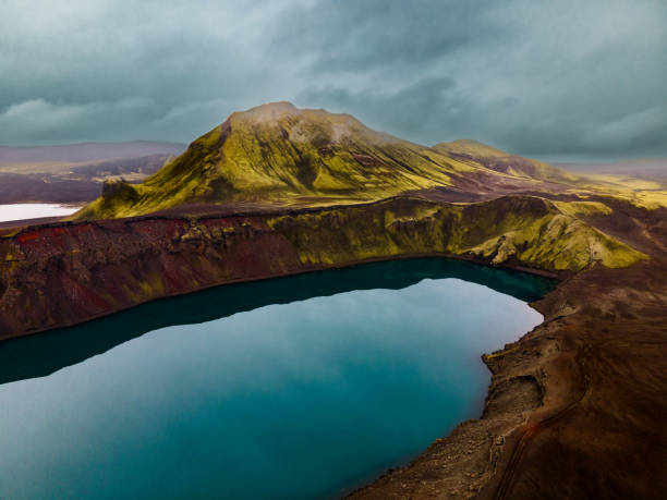 Light blue lake in the vulcano crater with green mountain in highlands scenery in Iceland
