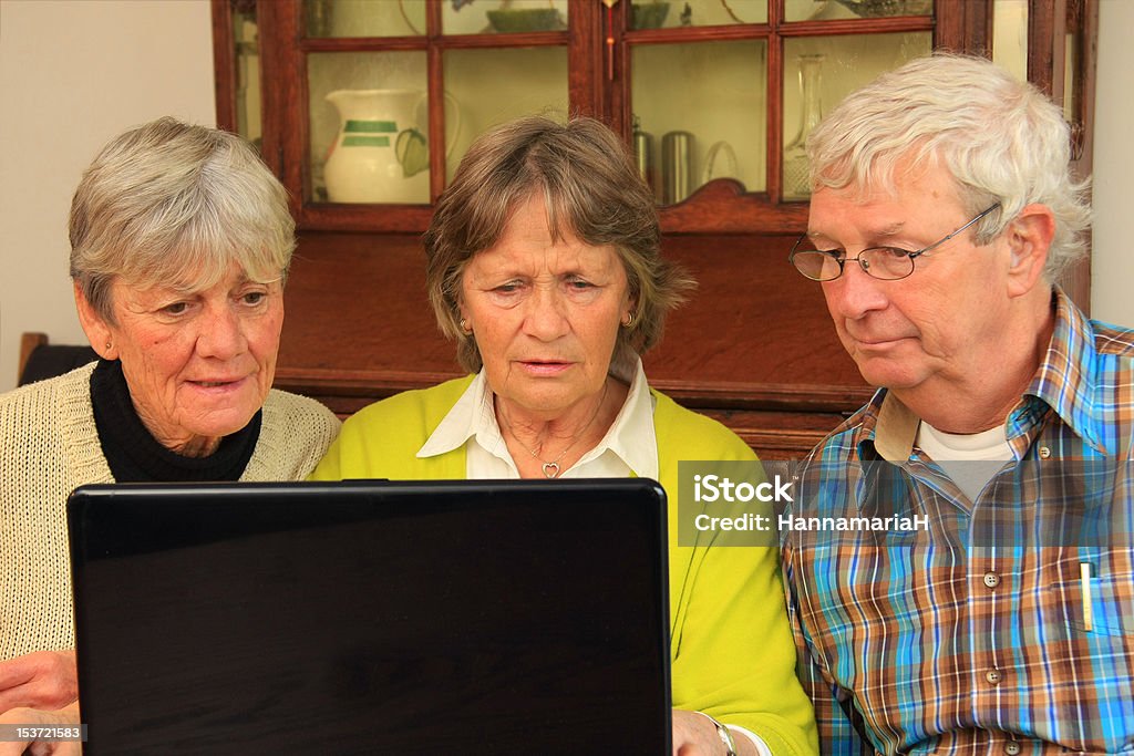 Senior citizens and the internet Three active senior citizens surfing the internet. 65-69 Years Stock Photo