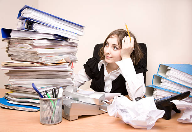 Young businesswoman with tons of documents stock photo