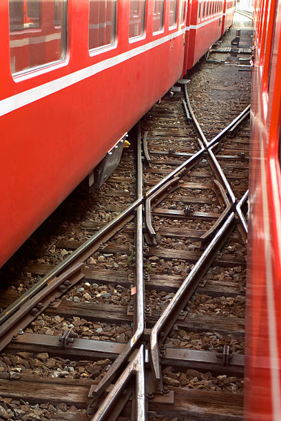 istock Railroad cross between two red swiss trains 153724101