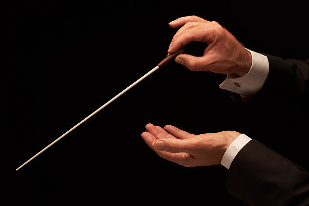 Conductor conducting an orchestra stock photo