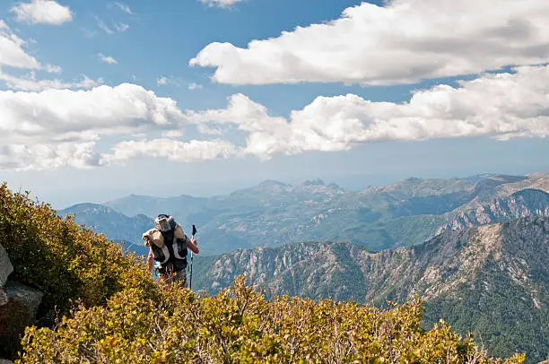 Nature around famous hiking path GR20 at Corsica with a trekker on the way to next cabin.