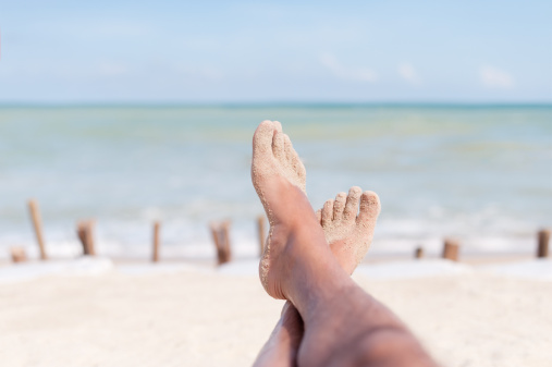 Human Feet Up on the Beach relaxing