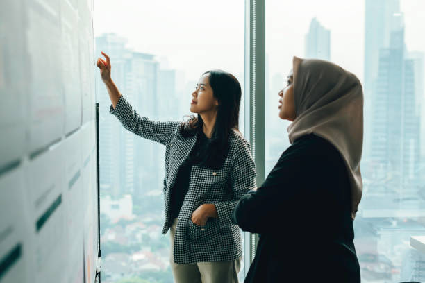 Asian people working and discussion on whiteboard in office
