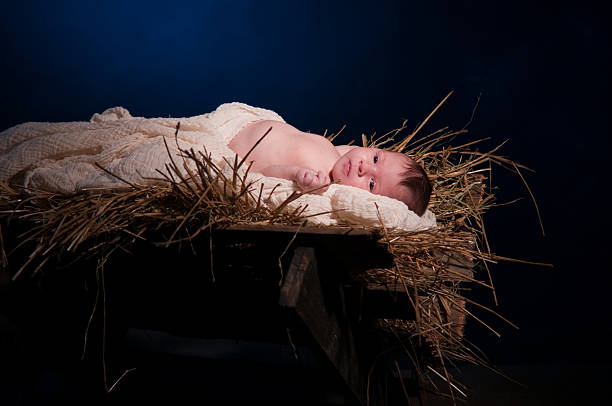 Close-up of a baby laying in the manger like Jesus stock photo