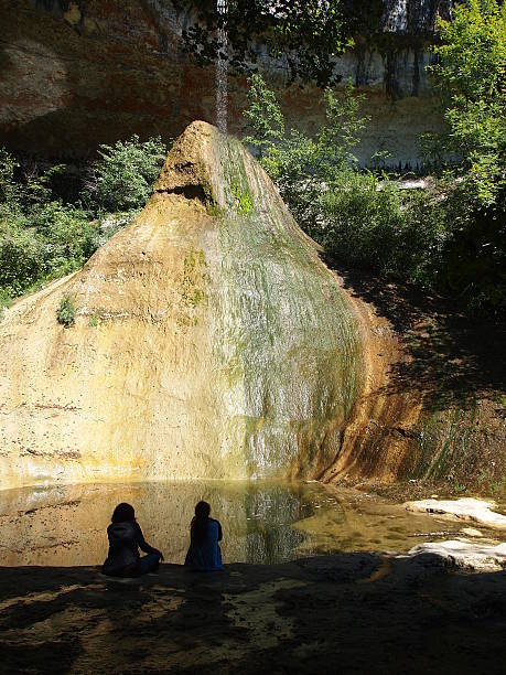 Two girls in the shadow looking a river falling on stock photo