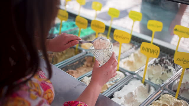 Female Scooping Different Flavors Of Ice Cream For Customer