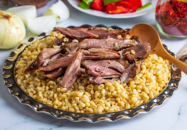 turkish foods; lamb shank tandoori on bulgur wheat rice (turkish name; bulgur bugday pilavi kuzu incik tandir, kuzu tandir) - lamb shank dinner meal imagens e fotografias de stock