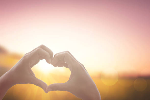 istock hand and heart shape at sunrise background 1537287417