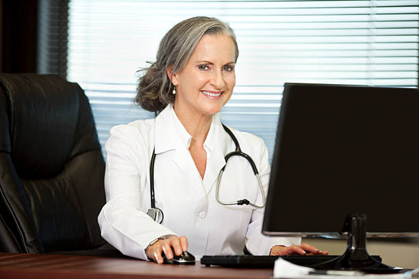 A female medical professional smiling with a stethoscope stock photo