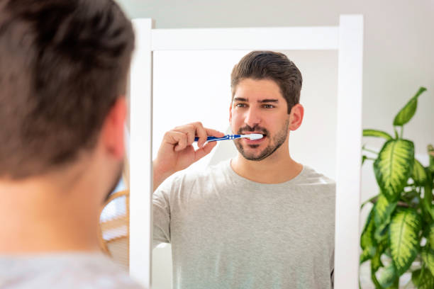 istock A stubble faced man standing in the bathroom at home and brushing his teeth 1537299220