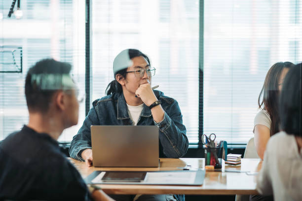 Asian chinese young man concentration and listening in meeting room stock photo