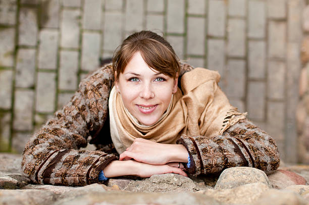 Young woman near the gray stone wall