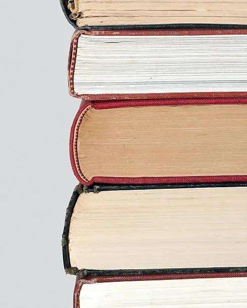 Red and black books stacked, showing a closeup of the book spines and one side.