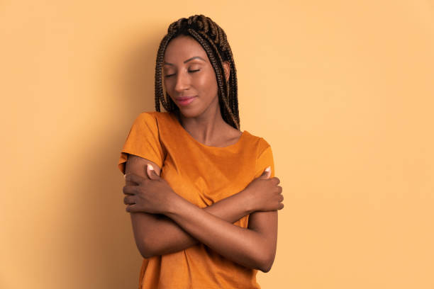 istock woman embracing self, hugging in beige studio 1537322204