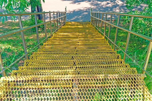 Yellow metal staircase with shiny railings