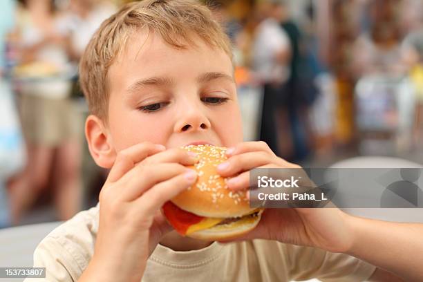 Little Caucasian Boy Eating Burger Looking Down Stock Photo - Download Image Now - Burger, Eating, Boys