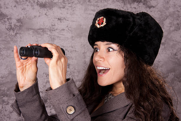 russian spia guardando attraverso il binocolo - russian culture women spy russia foto e immagini stock