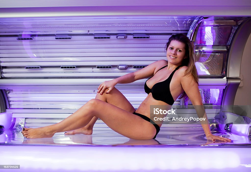 Joven mujer posando en la cama solar - Foto de stock de 20 a 29 años libre de derechos
