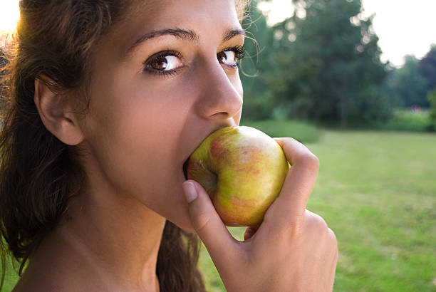 istock Girl eating apple and looking at camera 153734714