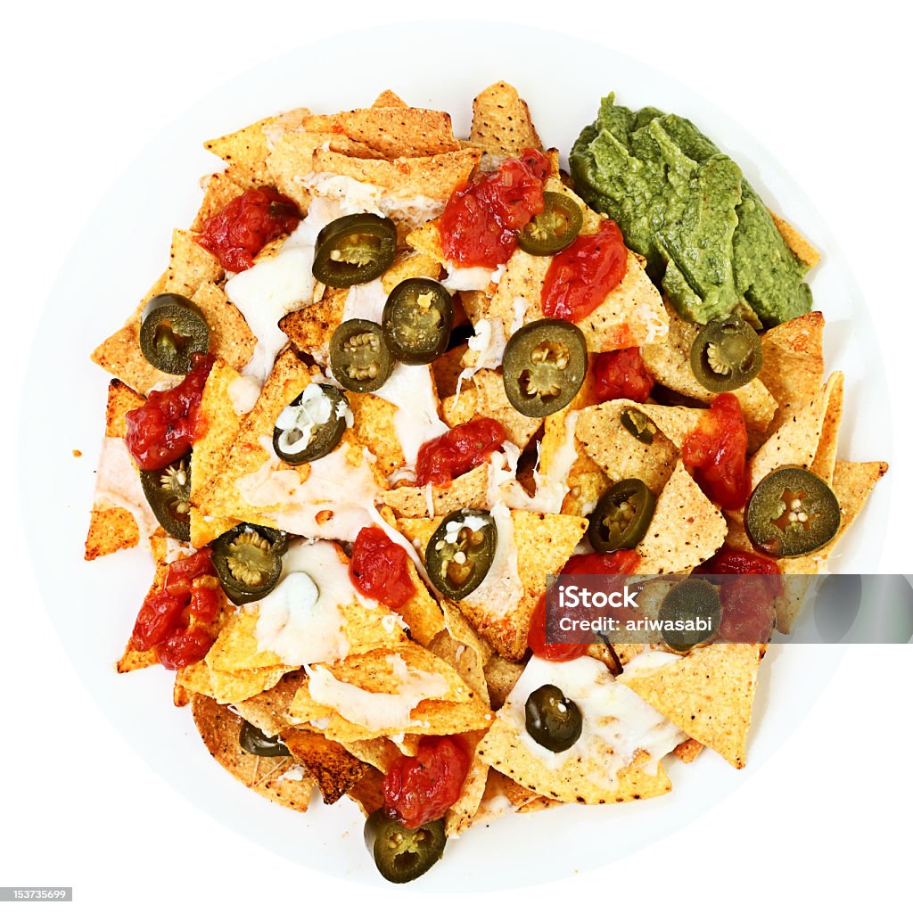 Nachos covered in cheese, jalapee Nachos plate with jalapenos, chilli, mozzarella cheese, guacamole and spicy tomato salsa. Isolated on white background. See more Nacho Chip Stock Photo