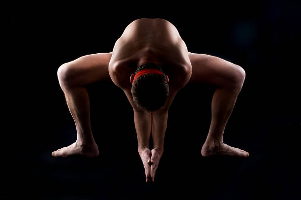 Naked athlete Silhouette of a young, handsome, naked man, standing with legs spread, like stripper in yoga pose yoga nudist silhouette naked stock pictures, royalty-free photos & images