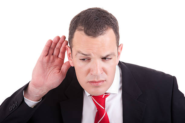 businessman, listening, viewing the  gesture of hand behind ear stock photo