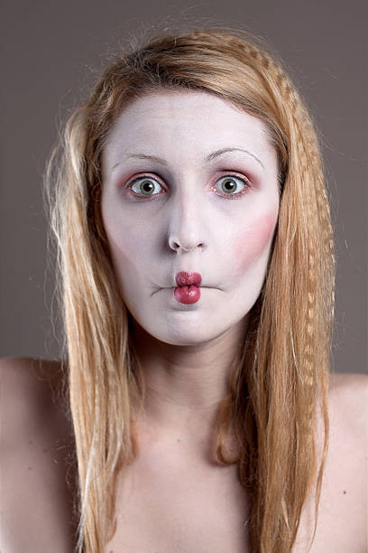 istock White face painted girl imitating small mouth 153736519