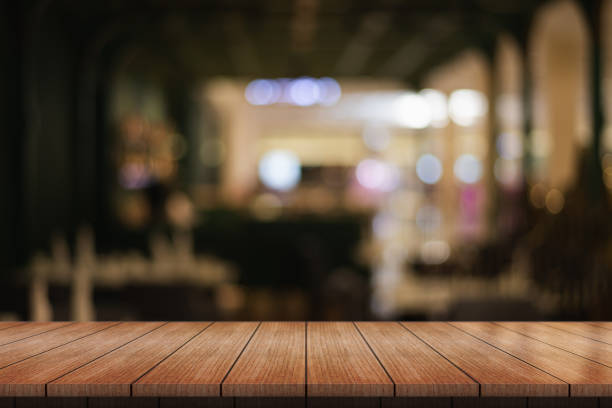 istock Empty wooden table top with lights bokeh on blur restaurant background. 1537374810