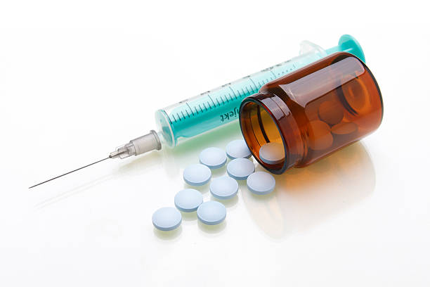 istock Blue syringe and light blue pills with bottle 153737519