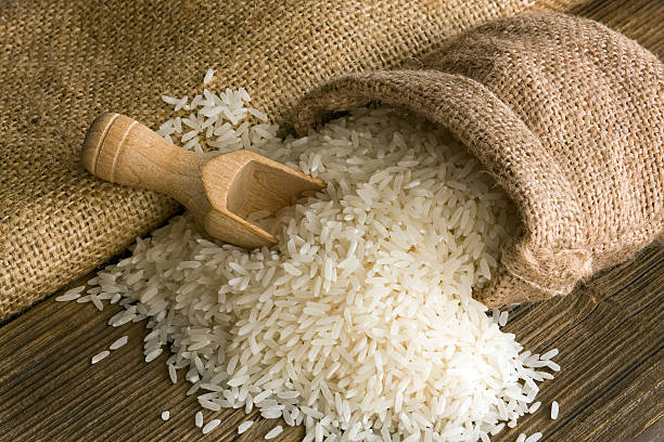 Rice White uncooked rice in small burlap sack rice food staple stock pictures, royalty-free photos & images