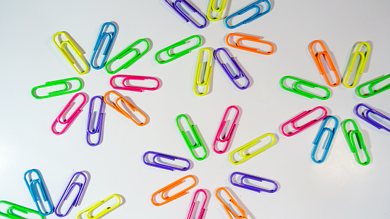 Bunch of colorful paper clips on the table .