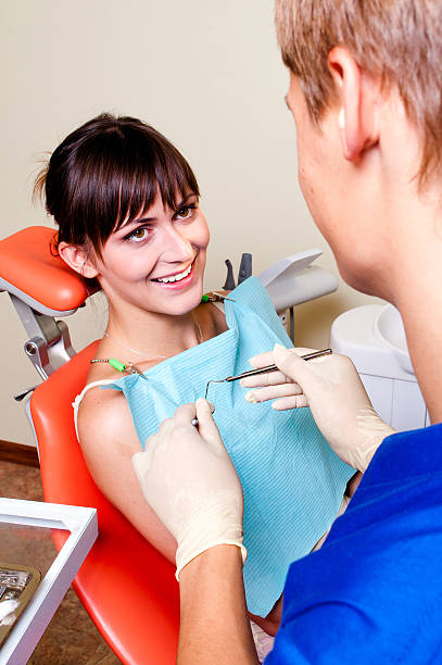 istock Young dentist giving a treatment to his patient 153739270