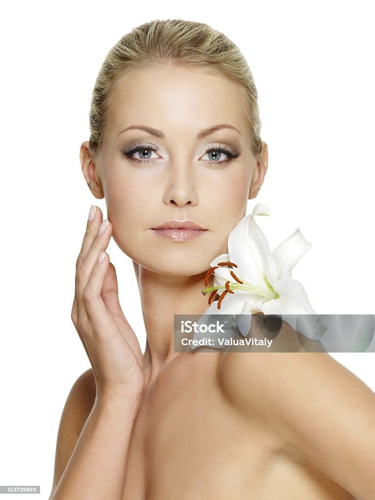 Beauty face of the young beautiful woman with flower Beauty face of the young beautiful woman with flower. Female touching skin. Girl on white background 20-29 Years Stock Photo