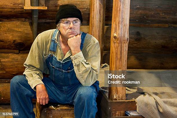 Man Sitting In His Log Cabin Thinking Stock Photo - Download Image Now - Adult, Bachelor, Bed - Furniture